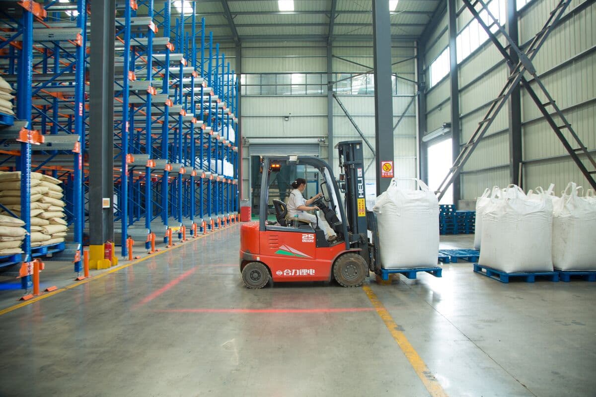 Forklift handling a bulk bag in the warehouse